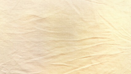 soft wrinkled beige fabric texture closeup gentle folds warm golden hues neutral background wallpaper copy space banner