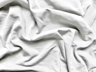 elegant white fabric crumpled in soft rippling folds on pastel blue surface evoking serene minimalism perfect for abstract wallpaper or copy space banner