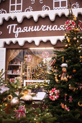 A Christmas tree decorated with gingerbread men and red bows on the city streets
