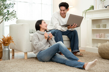 Couple Relaxing at Home in Winter While Using a Laptop and Enjoying Drinks Together