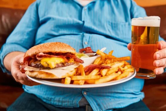 Overweight man with a hamburger, fries, and a beer