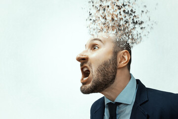 Portrait of a screaming man in a business suit with an exploding head.