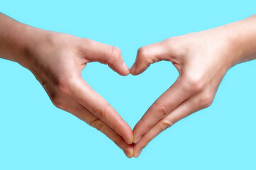 Obraz premium Two hands folded into the shape of a heart on a blue background.