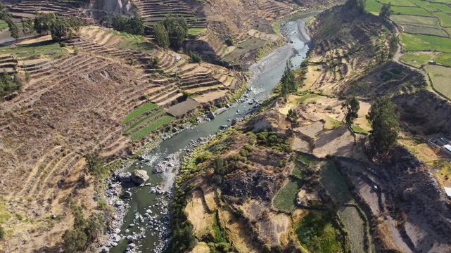 Aerial drone shot pulling back to reveal Colca River and Colca Valley, Peru