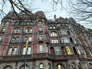 Historic red brick building in Manchester UK with ornate facade and decorative balconies