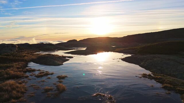 Frozen Lake in Serra da Estrela Mountains at Sunrise. Ice and Clouds. Portugal. Drone Shot. Moving Forward at Low Level