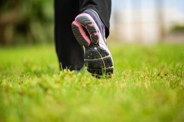 Close-up of athletic shoes walking on green grass