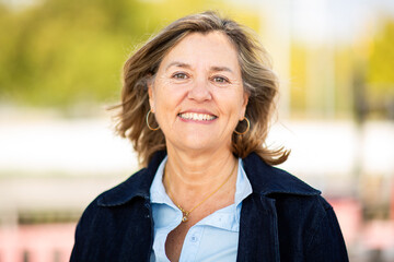 Smiling mature woman portrait outdoors in urban park