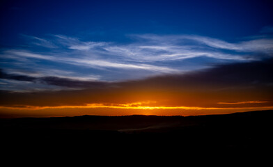 Dramatic sunset background with cloudy sky.