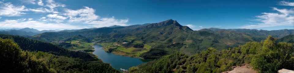 Obraz premium Panoramic view of lush green valley and majestic mountain under blue sky