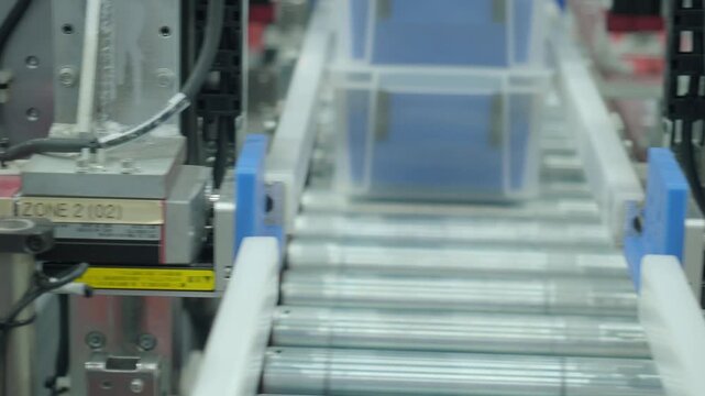 Automated conveyor line. Auto system moving plastic storage bins through modern factory line. Industrial machinery rollers and precision automation. Efficient conveyor belt smart logistics technology