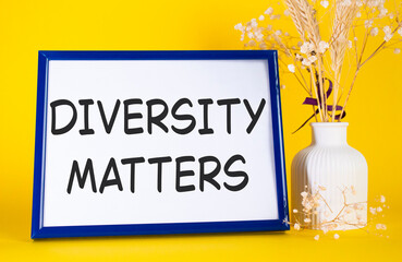 Diversity matters symbol. Concept words Diversity matters on beautiful wooden picture frame. Beautiful yellow background with flower vase. Business and Diversity matters concept. Copy space.