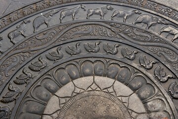 Obraz premium Intricate stone carving featuring animal motifs in concentric circles.
