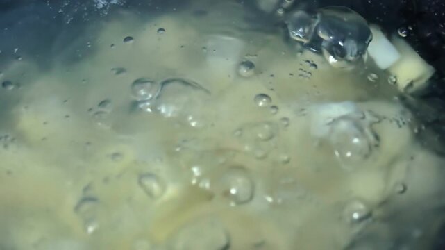 Water boiling with steam and bubbles, creating a dynamic liquid texture