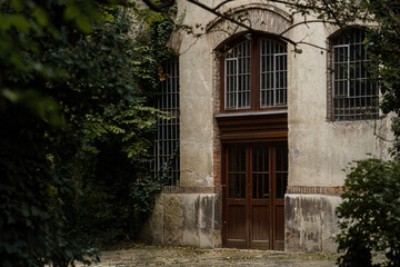 Old building exterior with wooden doors and greenery