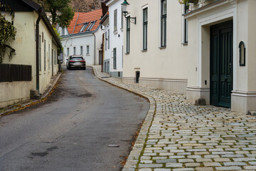 Car driving on narrow historic street in Austrian village