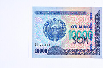 A 2017 banknote of 10000 Uzbek soums. The obverse depicts the state emblem. The reverse side of the banknote features an image of the Senate building in Tashkent.