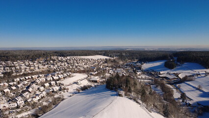 Aerial view of rural landscape with fields and forest under blue sky