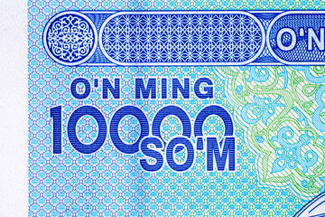 A 2017 banknote of 10000 Uzbek soums. The obverse depicts the state emblem. The reverse side of the banknote features an image of the Senate building in Tashkent.