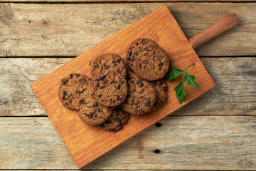 Freshly Baked Chocolate Chip Cookies on a Wooden Board With Green Garnish