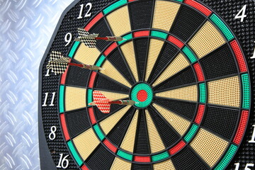 Drei Dartpfeile stecken pr&auml;zise in der Dartscheibe. Die kr&auml;ftigen Farben und der metallische Hintergrund betonen den Moment sportlicher Konzentration.