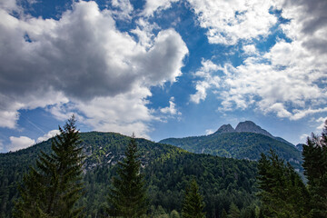 vista panoramica su di un ambiente naturale di montagna tra le Alpi del nord Italia, di giorno, con cielo a met&agrave; tra il sereno ed il nuvoloso, in estate