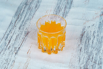 This fresh seeded orange juice, rich in natural fruit pulp and essential vitamins. Chilled in a clear glass isolated on a textured rustic surface. Perfect for diet promotion.