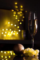 Bunch of grapes next to champagne glass and mask for New Year's Eve