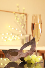 Bunch of grapes next to champagne glass and mask for New Year's Eve