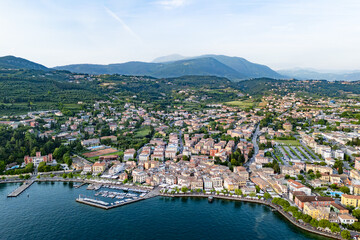 Aerial of Lake Garda with the town of Garda visible along the waterfront, framed by mountains in the background