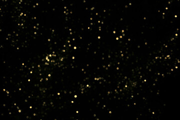 Golden night sky of scattered glittering particles on deep black background, evoking distant...