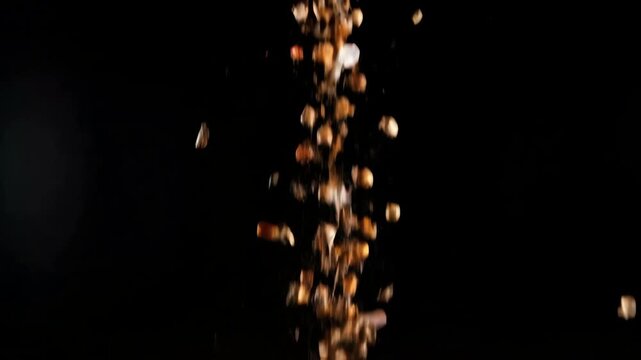 A vibrant mix of exotic spices and seasonings exploding upwards in dramatic slow motion against a solid black background.