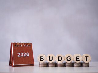 2026 desk calendar and Wooden blocks with the word BUDGET on stack of coins. The concept about budget planning and allocation in year 2026