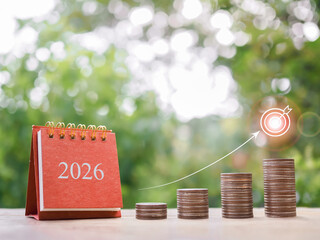 2026 desk calendar, Stack of coins with arrow rising and target icons. The concept of business growth, Financial investment, Market stock, Profit return, Dividend and Business fund in year 2026