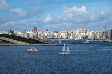 Fototapeta premium View from Valletta over Sliema and Tigné Point, showing the coastal land bridge with modern high-rise buildings and the blue Mediterranean sea Valletta, Malta, 6 DEC 2025.