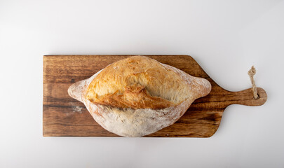 Farmer's bread lying on a wooden board, top view, space for text.