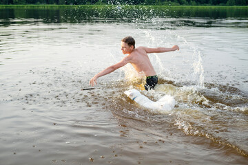 Man and dog play fetch in a lake, causing splashes and excitement. The man is throwing a stick, and...