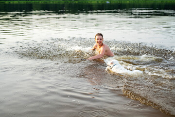 Fototapeta premium Man and Dog Splash in Water During Fetch Game