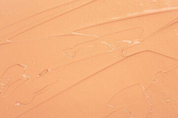 Abstract beige background of liquid powder foundation, top view. Delicate matte texture of the foundation. Mockup for cosmetics design. Bb or cc cream foundation.