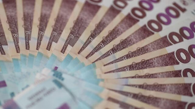 One thousand hryvnia bills with Mykhailo Hrushevsky portrait on obverse on white background closeup. National currency of Ukraine rotates on table upper view. Business success and money savings
