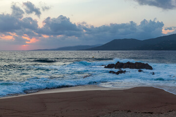 Dramatic view of shoreline with rocky formations and gently lapping waves. Corsica