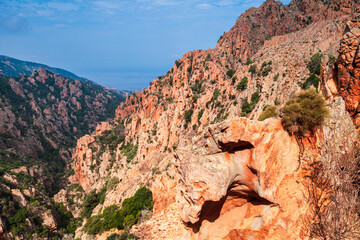 Landscape of Calanques de Piana, Corsica, France. Red rocks are under cloudy sky