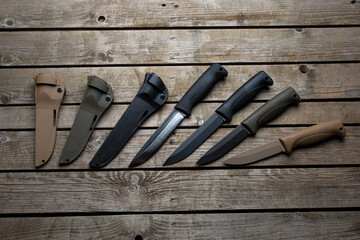 Tactical survival knives on wooden background