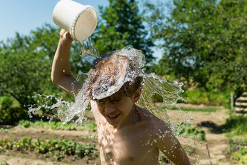 A teenage boy is doused with water