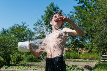 A teenage boy is doused with water