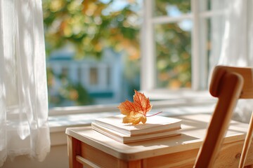 Autumn leaf on books by the window