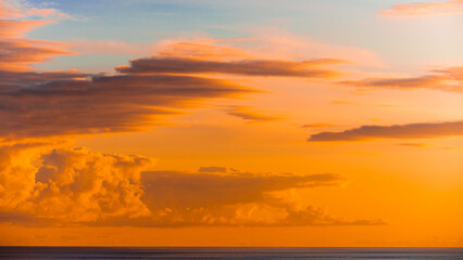 Obraz premium Golden Sunset Over the Sea with Vivid Pink and Orange Clouds