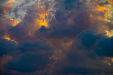 Beautiful evening sky filled with heavy cumulus clouds illuminated by the setting sun