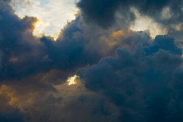 Beautiful evening sky filled with heavy cumulus clouds illuminated by the setting sun