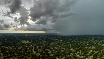 Heavy rain falling down from stormy clouds over rural Florida suburbs. Thunderstorm on dark sky. Moving and changing cloudscape weather